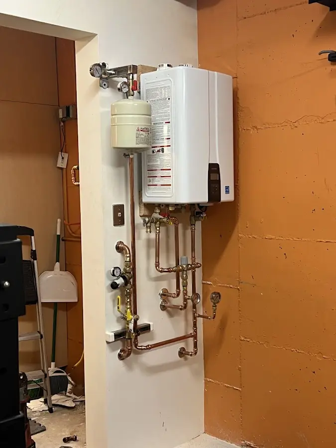 Plumbing technician inspecting water heater connections in Knox